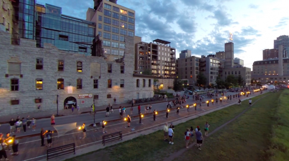 A walking promenade outlines a downtown cityscape at dusk.